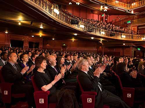 Audience applauding in performing arts theater.